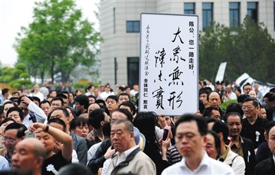 前来送别陈忠实的群众，有人手举手写书法(图)，有人高举印有陈忠实纪念专号的报纸。 图/视觉中国