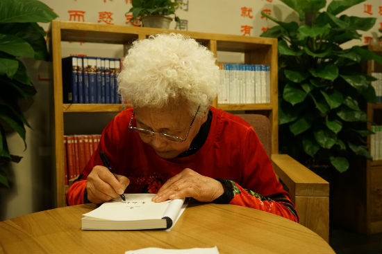 姜淑梅奶奶一笔一划地为读者签名